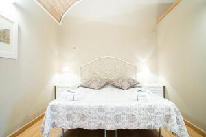 una camera da letto con un letto con copriletto bianco di Le Erbe Guest House a Viterbo