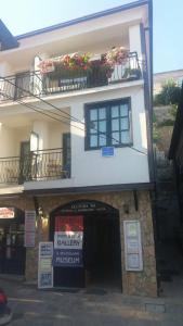 a white building with two balconies with flowers on it at Apartmani Marija in Ohrid