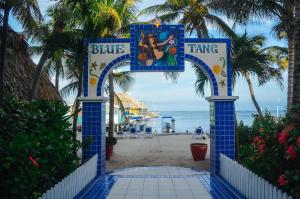 um sinal azul e branco na praia em Blue Tang Inn em San Pedro