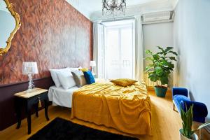 - une chambre avec un lit et une couverture jaune dans l'établissement Santa Ana Boutique, à Madrid