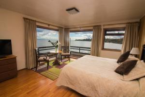 a bedroom with a bed and a view of the water at Hotel Terrazas del Lago in Puerto Varas
