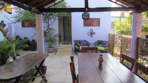 an outdoor patio with a wooden table and chairs at Pousada da Lucinha in Canoa Quebrada