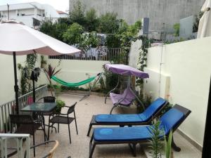 un patio con sillas, mesas y una sombrilla en Residencial Sol da Nave, en Oporto
