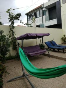 a green hammock and an umbrella on a patio at Residencial Sol da Nave in Porto