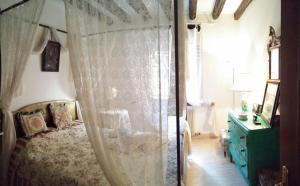 ヴェネツィアにあるResidenza Ofeliaのベッドルーム1室(カーテン付きのベッド1台、ドレッサー付)