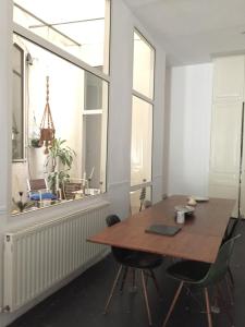 une salle à manger avec une table en bois et une grande fenêtre dans l'établissement Liberté, à Marseille