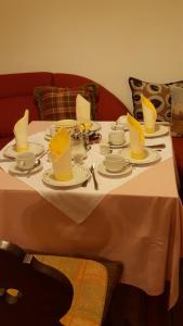 a white table with yellow hats and plates on it at Haus Mühlgraben in Ramsau