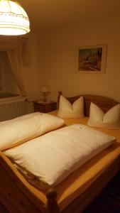 1 dormitorio con 2 camas con sábanas blancas y lámpara en Haus Mühlgraben, en Ramsau