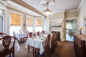 a dining room with tables and chairs and a fireplace at O Canada House Bed & Breakfast in Vancouver