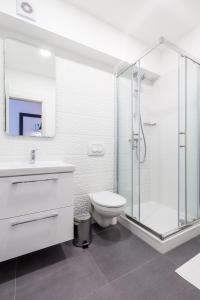 a bathroom with a toilet and a glass shower at Flumen in Rijeka +21 photos