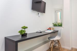 a desk in a room with a tv on a wall at Flumen in Rijeka