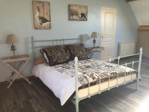 a bed in a bedroom with two tables and two lamps at Villa Cotentin in Réville