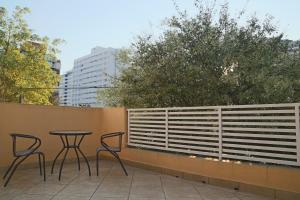a patio with two chairs and a table on a fence at Villa Hostel SP - Próximo ao Allianz Parque in Sao Paulo