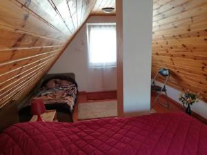a bedroom with a red bed and a window at Tiszavirág Vendégház in Szeged
