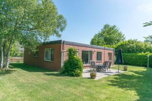 a small red brick house with a patio at Hello Zeeland - Vakantiehuis Het Heem 39 in Breskens