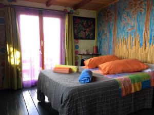 1 dormitorio con 1 cama con sábanas coloridas y ventana en Casa sull'Albero en Lentella