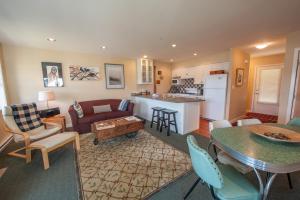 托菲諾的住宿－Waterfront Condo by OnlyBC 202，客厅以及带沙发和桌子的厨房。