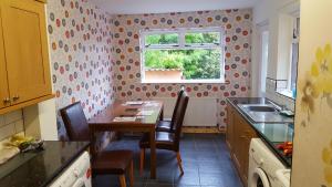 a kitchen with a table and chairs and a window at Alexandra Park House in Belfast
