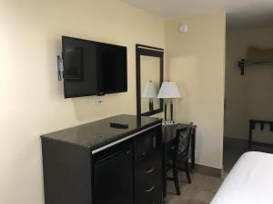 a hotel room with a desk with a television on the wall at Colton Inn in Colton