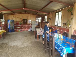 Cabañas Cinco Lagos في Santiago: امرأة تقف على طاولة في غرفة