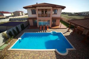 a house with a swimming pool in front of a house at Villa Magrib and Shark in Popovka