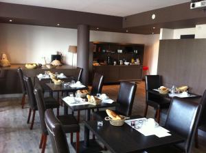 a restaurant with tables and chairs with food on them at Hôtel Bar le Globe in Saint Die