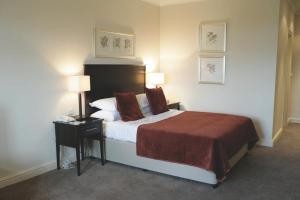 a hotel room with a bed and a table with a night stand at Macdonald Hill Valley Hotel Golf & Spa in Whitchurch