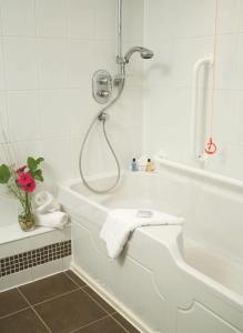 a bathroom with a shower and a tub with towels at Macdonald Hill Valley Hotel Golf & Spa in Whitchurch