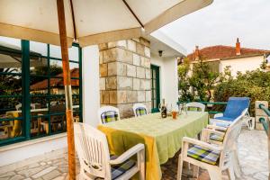 a patio with a table and chairs and a building at Villa Pavlović in Herceg-Novi