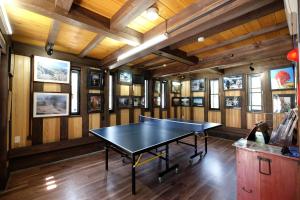 un tavolo da ping pong in una stanza con pareti in legno di Tsuyukusa a Takayama
