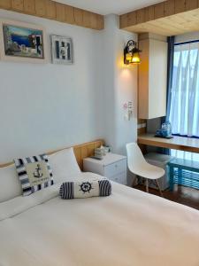 a bedroom with a large white bed and a desk at Sun Fog Hotel in Yuchi