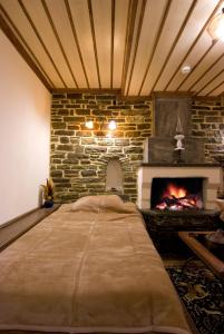 a bed in a room with a brick fireplace at Kato Machalas in Dikoryfo