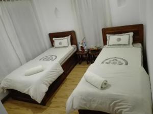 twee bedden naast elkaar in een kamer bij Sunny Guest House and Cafe in Bhaktapur