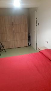 サッサリにあるLa cometaの赤いベッドと木製キャビネット付きのベッドルーム1室