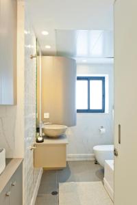 een badkamer met een wastafel, een toilet en een bad bij SHELTER in Elegant 2BR with Veranda close to Beach by FeelHome in Tel Aviv