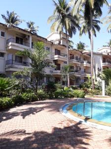 un complejo con piscina y palmeras en Mariano Gracinda resort, en Calangute