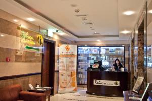 a woman sitting at a counter in a store at Ramee Rose Hotel in Dubai