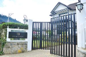 a gate to a house with a sign on it at Unique Cottages in Nuwara Eliya