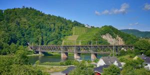 a bridge over a river with houses and a mountain at Ferienwohnung Brautrock in Bullay