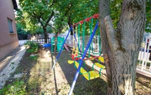 a swing in a tree next to a fence at Malomtavi Vendégház in Tapolca