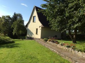 een wit huis met een tuin met bloemen bij Zurück zur Natur... in Vollrathsruhe