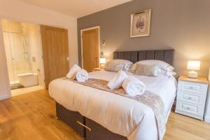 a bedroom with a large bed with towels on it at Razia Apts with easy access to Oxford Headington Hospitals in Oxford