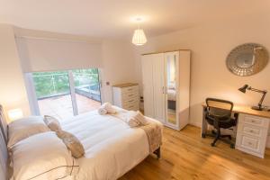 1 dormitorio con cama, escritorio y silla en Razia Apts with easy access to Oxford Headington Hospitals, en Oxford