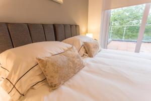 a bedroom with two pillows on a bed with a window at Razia Apts with easy access to Oxford Headington Hospitals in Oxford
