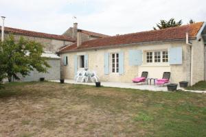 una casa con sillas rosas y un patio en Charmante maison charentaise "BONHEUR" * 4 pers, en Chambon