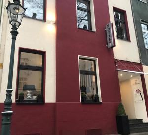 a red building with windows and a street light at Hotel Am Volksgarten in Düsseldorf