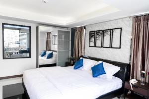 ein Schlafzimmer mit einem großen weißen Bett und blauen Kissen in der Unterkunft The Connex Asoke in Bangkok + 28 Fotos