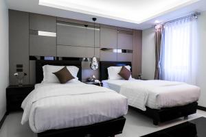 a bedroom with two beds with white comforters at The Connex Asoke in Bangkok +26 photos