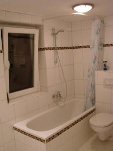 uma casa de banho com uma banheira, um WC e um lavatório. em Hannover Südstadt - Zimmer und Apartment em Hanôver