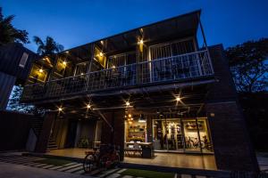 una casa con balcón por la noche en Ducati Bike Box Hotel en Buriram